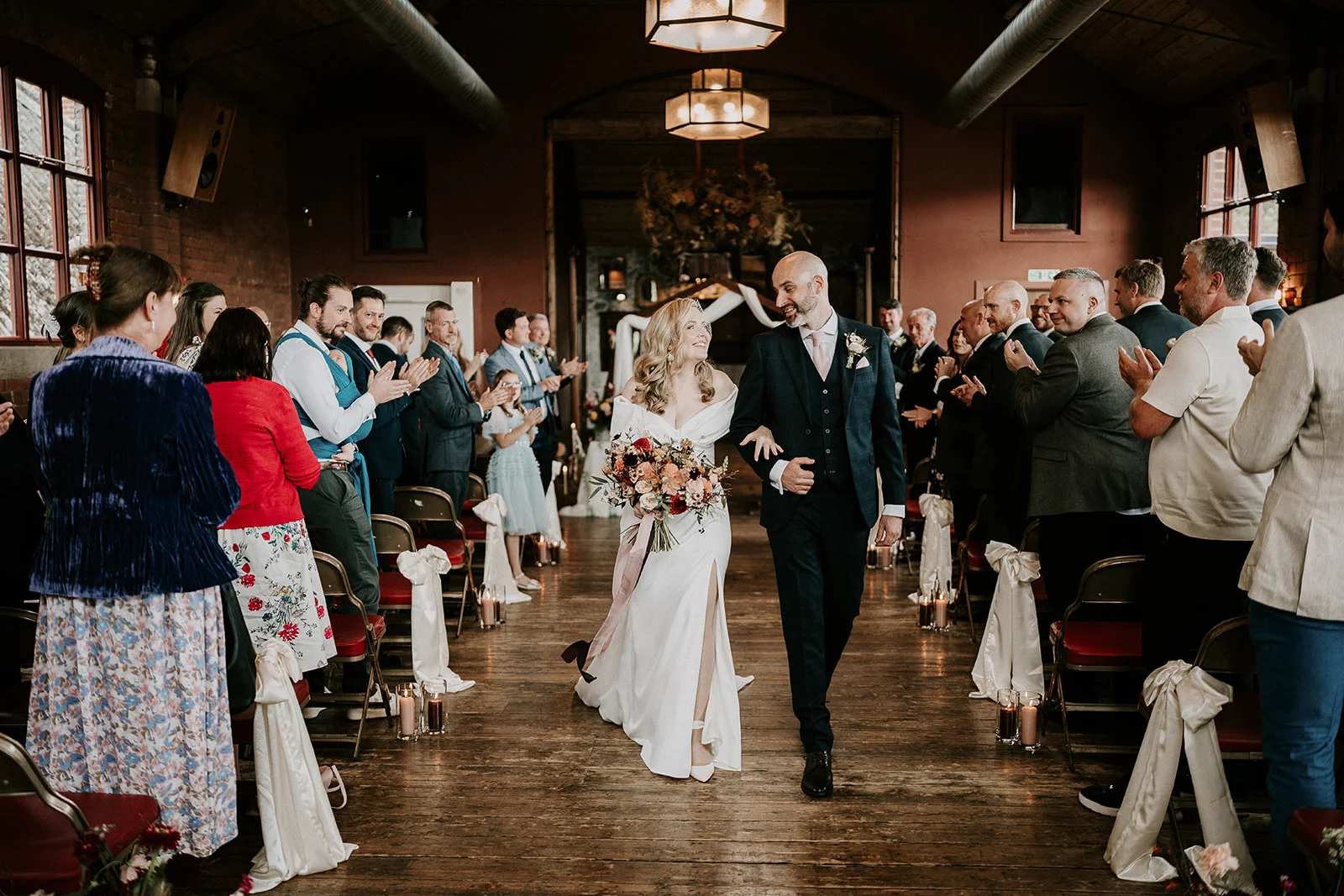 The married couple walking back down the aisle as husband and wife